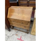 AN EARLY 20TH CENTURY OAK BUREAU WITH FALL FRONT AND TWO DRAWERS
