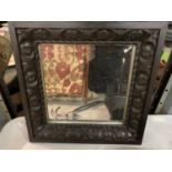 A SQUARE DARK WOODEN CARVED FRAMED BEVEL EDGED WALL MIRROR