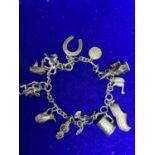 A SILVER CHARM BRACELET WITH TWELVE VARIOUS CHARMS