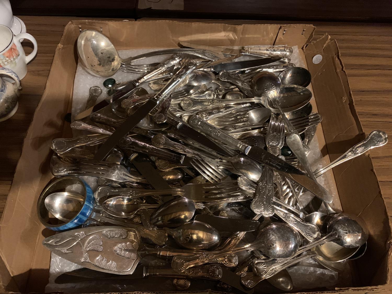 A LARGE ASSORTMENT OF FLATWARE TO ALSO INCLUDE A LADLE AND A GATEAU SERVER