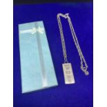 A SILVER INGOT AND CHAIN IN A PRESENTATION BOX