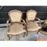 A PAIR OF CONTINENTAL STYLE OPEN ARM CHAIRS WITH BUTTON BACKS