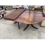 A MAHOGANY EXTENDING DINING TABLE ON TWIN PEDESTAL SUPPORTS