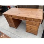 A PINE TWIN PEDESTAL DESK WITH NINE DRAWERS