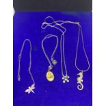 FOUR ASSORTED SILVER NECKLACES MARKED 925 TO INCLUDE A DRAGONFLY AND SEAHORSE PENDANTS ETC