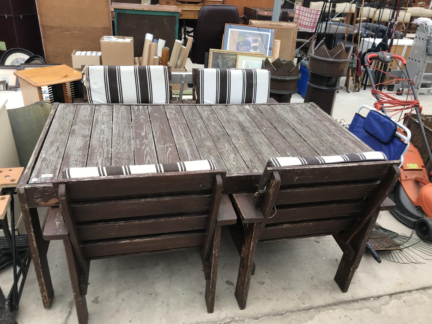 A FOUR SEATER WOODEN GARDEN TABLE WITH FOUR CHAIRS COMPLETE WITH CUSHIONS