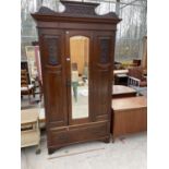 AN EARLY 20TH CENTURY CARVED MAHOGANY WARDROBE WITH LOWER DRAWER AND BEVEL EDGE MIRRORED DOOR