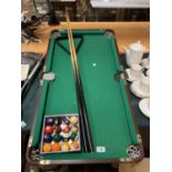 A TABLE TOP SNOOKER TABLE TO INCLUDE TWO CUES AND A SET OF SNOOKER BALLS