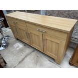A MODERN LIGHT OAK EFFECT SIDEBOARD ENCLOSING TWO DRAWERS AND FOUR CUPBOARDS, 64" WIDE