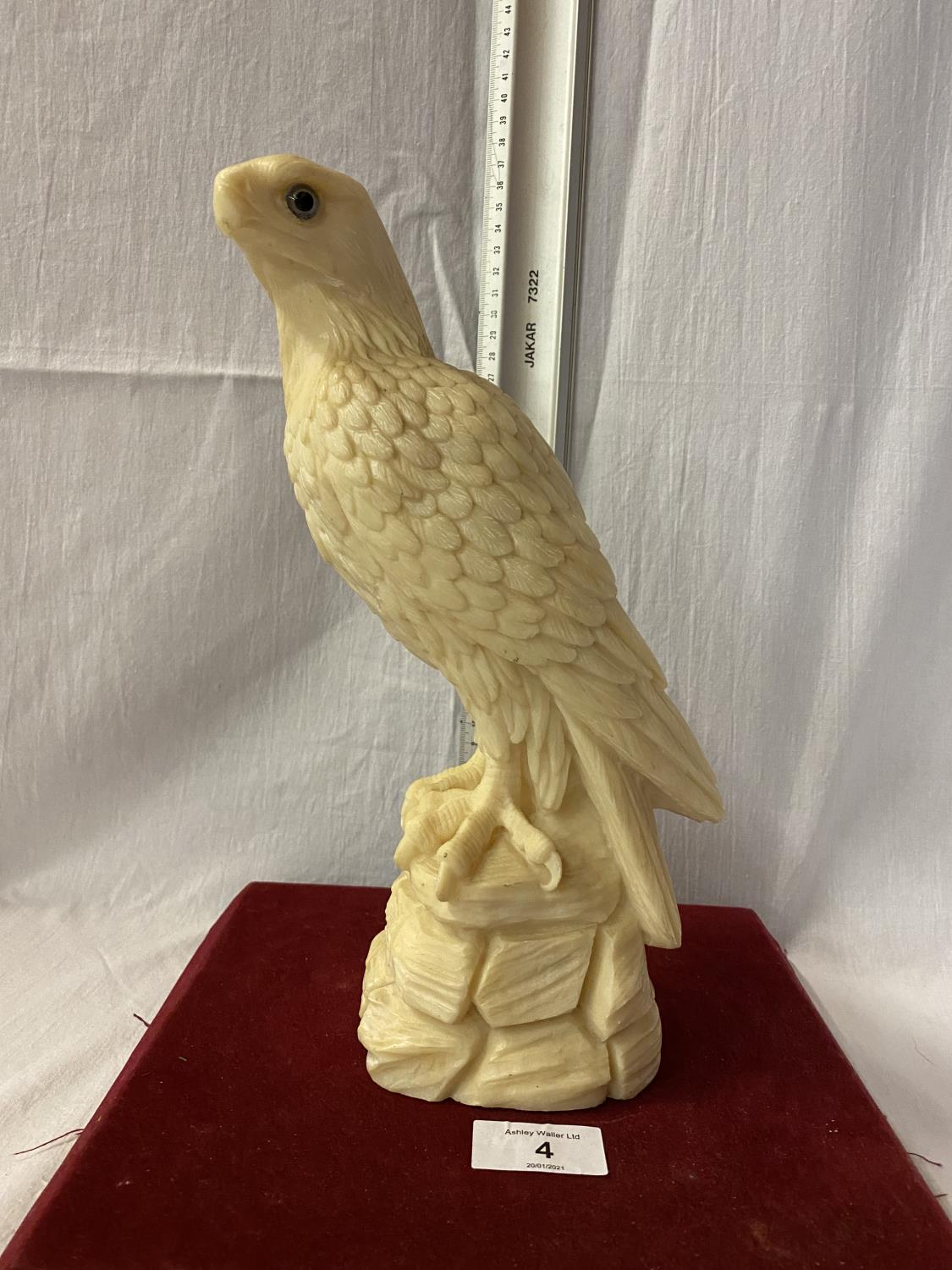 A RESIN FIGURE OF A BIRD OF PREY - HEIGHT 28CMS