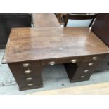 AN EARLY 20TH CENTURY OAK TWIN PEDESTAL DESK ENCLOSING NINE DRAWERS WITH BRASS SCOOP HANDLES, 54x20"