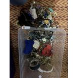 A SMALL CLEAR CONTAINER OF MIXED COSTUME JEWELLERY TO INCLUDE NECKLACES