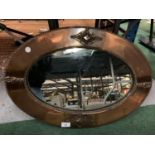 AN ARTS & CRAFTS STYLE ORNATE COPPER FRAMED OVAL LANDSCAPE MIRROR