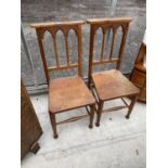 A PAIR OF VICTORIAN OAK HALL CHAIRS WITH GOTHIC STYLE BACKS