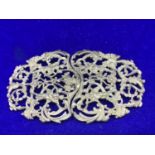 AN ORNATE WHITE METAL BUCKLE POSSIBLY SILVER