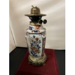 AN ORIENTAL CERAMIC AND BRASS OIL LAMP