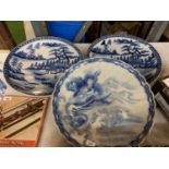 A PAIR OF LARGE BLUE AND WHITE ROUND PLATTERS IN THE ORIENTAL STYLE AND A FURTHER LARGE SHALLOW BLUE
