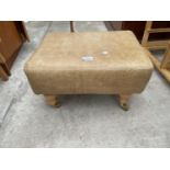 A MODERN LEATHER FOOT STOOL ON TURNED LEGS, COMPLETE WITH BRASS CASTORS