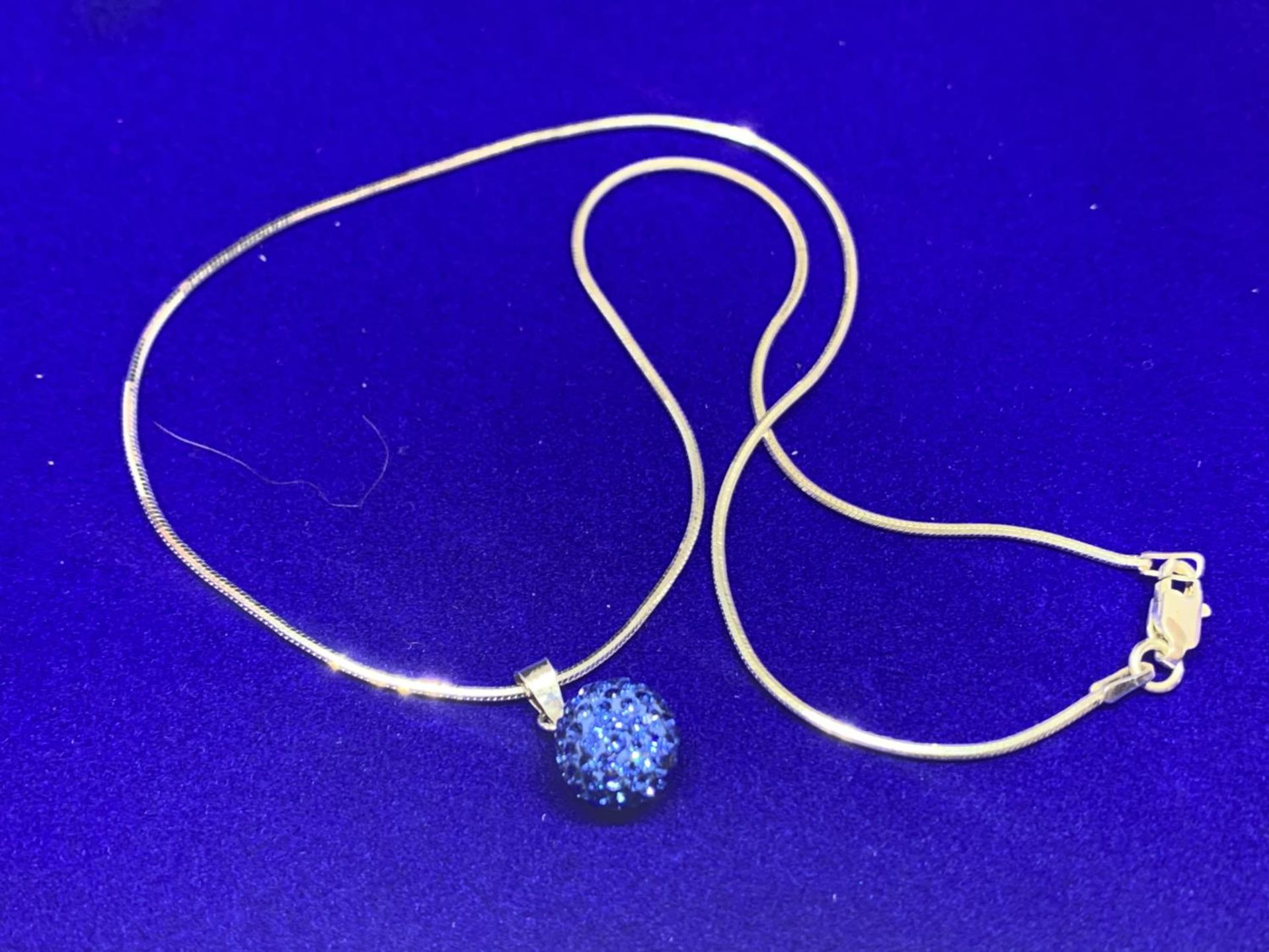 A SILVER CHAIN MARKED 925 WITH A BLUE CRYSTAL BALL PENDANT IN A PRESENTATION BOX