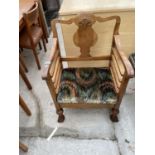 AN EARLY 20TH CENTURY WALNUT FRAMED LOW ELBOW CHAIR ON TURNED BULBOUS LEGS AND SCROLL FEET