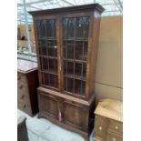 A 19TH CENTURY STYLE TWO DOOR GLAZED BOOKCASE ON OGEE FEET, WITH CUPBOARDS TO THE BASE, 40" WIDE