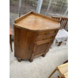 AN EARLY 20TH CENTURY OAK CORNER CABINET ENCLOSING THREE CUPBOARDS AND TWO DRAWERS, 42" WIDE