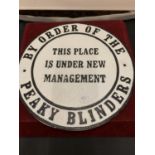 A CAST METAL PEAKY BLINDERS "UNDER NEW MANAGEMENT" CIRCULAR SIGN