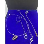 FOUR SILVER NECKLACES TO INCLUDE PENDANTS WITH THREE STONES, S SHAPE, INGOT YELLOW STONES ETC