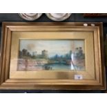 A FRAMED WATERCOLOUR OF A CASTLE AND RIVER SCENE