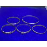 FIVE VARIOUS SIZED SILVER BANGLES