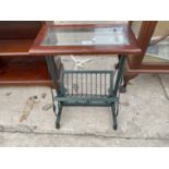 A METALWARE MAGAZINE RACK/TABLE WITH GLASS TOP