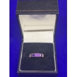 A 9 CARAT GOLD RING MARKED 375 WITH FIVE IN LINE PURPLE STONES SIZE M GROSS WEIGHT APPROXIMATELY 2.9