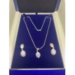 A BOXED NECKLACE WITH AN OPAQUE STONE SET IN A SILVER PENDANT WITH MATCHING EARRINGS ALL MARKED
