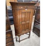 AN EARLY 20TH CENTURY OAK SINGLE DOOR CORNER CUPBAORD ON OPEN BASE, 30" WIDE