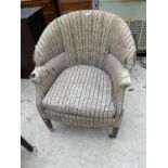 AN EDWARDIAN UPHOLSTERED TUB CHAIR ON TAPERED LEGS