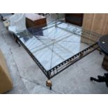 A VERY LARGE COFFEE TABLE WITH GLASS TOP AND GILDED IRON SUPPORTS