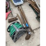 AN ASSORTMENT OF VINTAGE GARDEN TOOLS TO INCLUDE A RAKE, A HOE AND A HOSE PIPE ETC