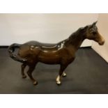 A BESWICK SWISHING TAIL HORSE IN BROWN GLOSS