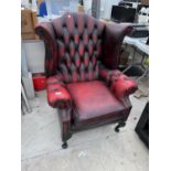 AN OX BLOOD LEATHER WING AND BUTTON BACK ARMCHAIR