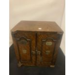 A SMALL VINTAGE SMOKING COMPENDIUM IN THE FORM OF A WOODEN SAFE WITH BRASS DETAIL HEIGHT: 32CM (A/F)