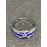 A SILVER RING MARKED 925 WITH BLUE AND CLEAR STONES IN AN ART DECO STYLE