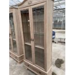 A LIMED OAK TWO DOOR DISPLAY CABINET