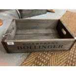 A STURDY WOODEN 'CHAMPAGNE BOLLINGER' CRATE WITH METAL CORNER DETAIL