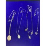 FOUR SILVER NECKLACES WITH PENDANTS TO INCLUDE A ST CHRISTOPHER, BLUE CAMEO, FLOWER ETC
