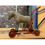 A VINTAGE HORSE PUSH ALONG ON WHEELS