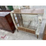 A 1950'S SHINY WALNUT EFFECT GLASS DISPLAY CABINET WITH TWO PAINTED GLASS SLIDING DOORS AND MIRRORED