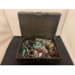 A LARGE ORNATE WOODEN AND FAUX LEATHER BOX CONTAINING A COLLECTION OF COSTUME JEWELLERY