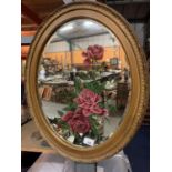 AN OVAL GILT FRAMED MIRROR WITH RED ROSE DESIGN