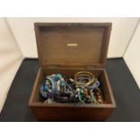 A VINTAGE WOODEN BOX CONTAINING COSTUME JEWELLERY