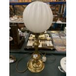 A BRASS TABLE LAMP WITH WHITE GLOBE SHADE BELIEVED IN WORKING ORDER BUT NO WARRANTY